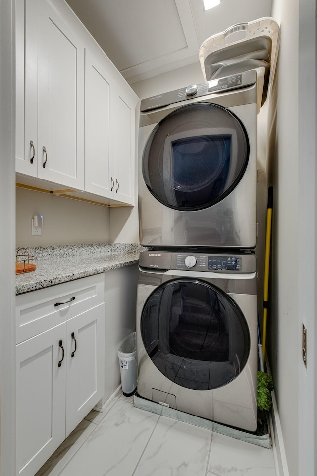 laundry room featuring stacked washer / dryer and cabinets