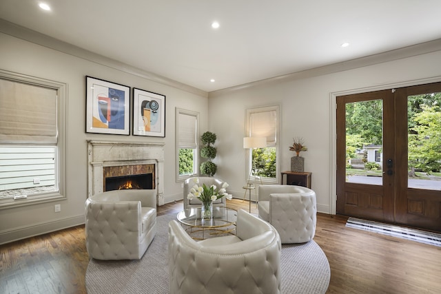 living room featuring a high end fireplace, dark hardwood / wood-style floors, french doors, and ornamental molding