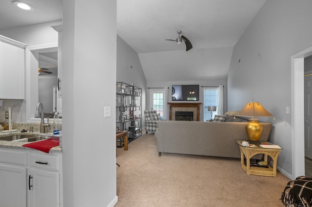 carpeted living room with lofted ceiling, sink, and a tile fireplace