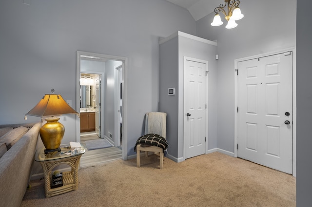 entryway with a chandelier, light carpet, and vaulted ceiling