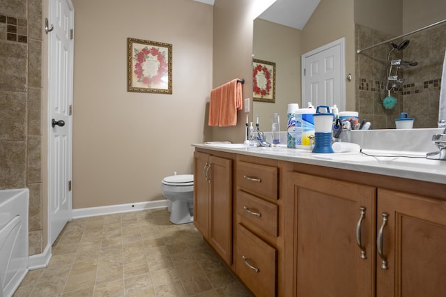 bathroom featuring toilet, a tile shower, and vanity