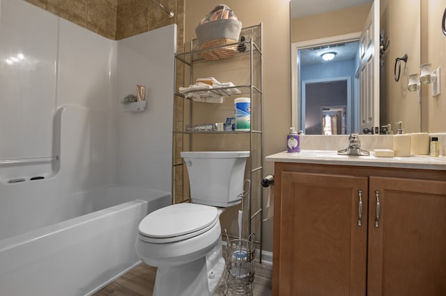 full bathroom featuring hardwood / wood-style floors, toilet,  shower combination, and vanity