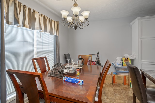 dining area with a textured ceiling, a wealth of natural light, and an inviting chandelier