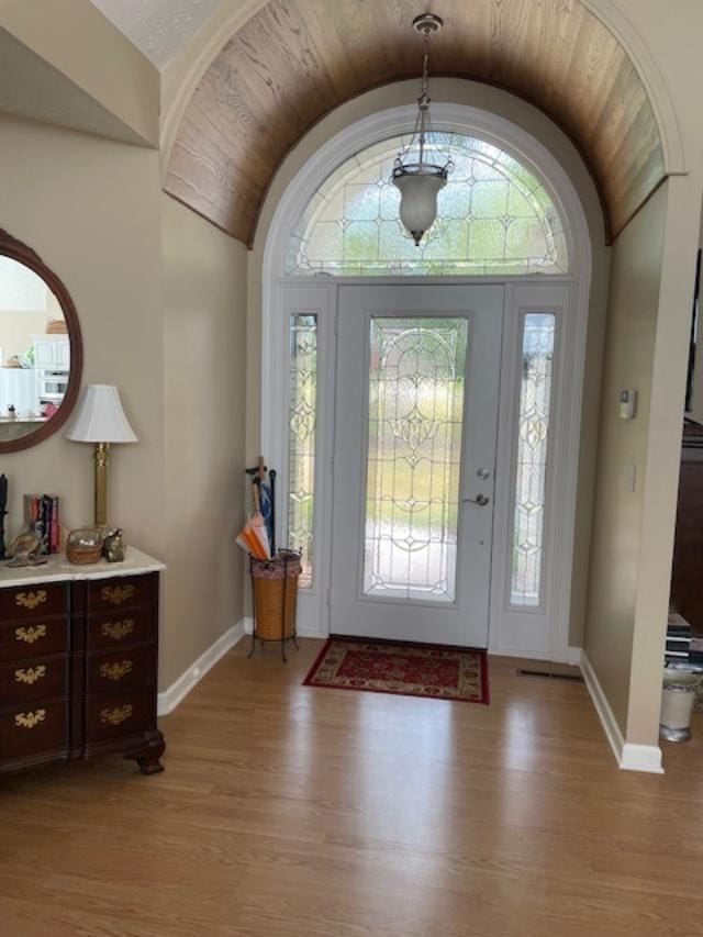 entryway featuring lofted ceiling, a wealth of natural light, and light wood-type flooring