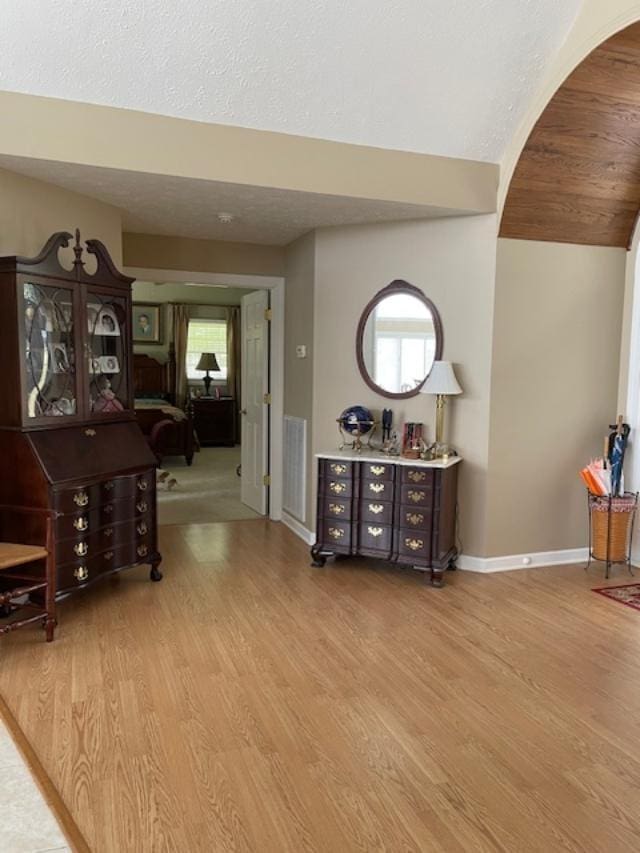 hallway featuring hardwood / wood-style flooring, plenty of natural light, and a textured ceiling