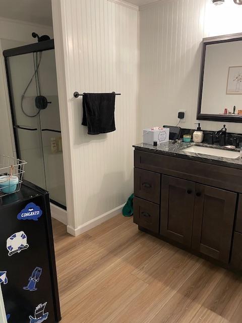 bathroom with vanity, hardwood / wood-style floors, and a shower with shower door