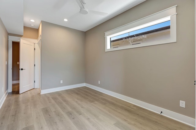 spare room featuring light wood finished floors, ceiling fan, baseboards, and recessed lighting