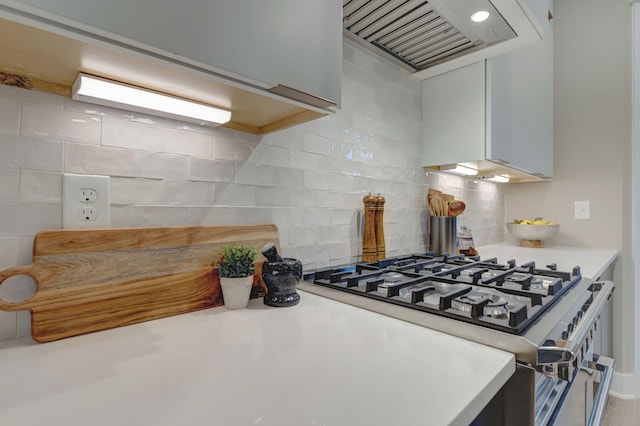 kitchen with white cabinetry, decorative backsplash, stainless steel gas range oven, and custom range hood