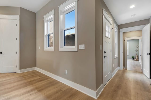 foyer entrance with recessed lighting, light wood-type flooring, and baseboards