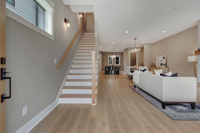 living room with an inviting chandelier and light hardwood / wood-style floors