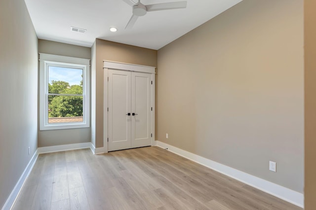 unfurnished bedroom with light wood finished floors, a closet, visible vents, a ceiling fan, and baseboards