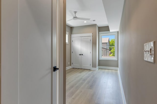 hallway with light wood-type flooring, baseboards, visible vents, and recessed lighting