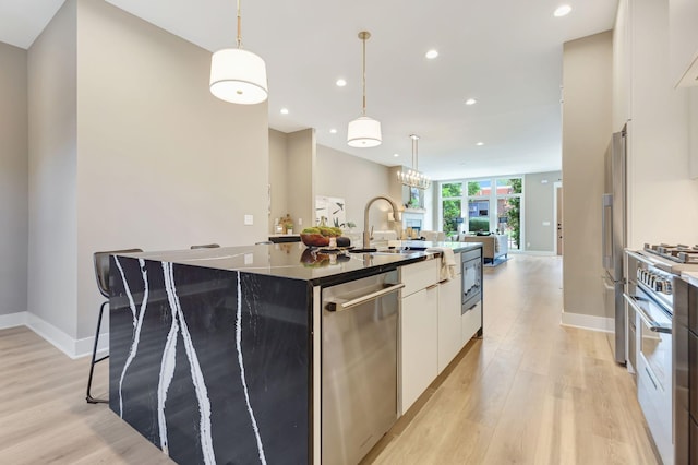 kitchen featuring a kitchen island with sink, recessed lighting, stainless steel appliances, white cabinets, and light wood finished floors