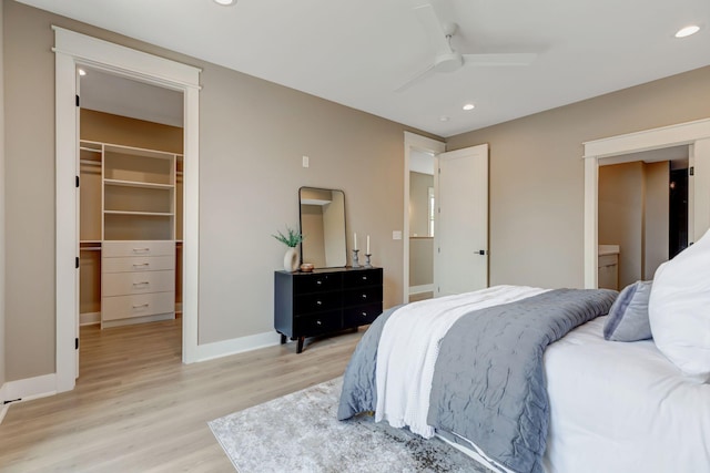 bedroom featuring baseboards, a spacious closet, light wood-style floors, a closet, and recessed lighting