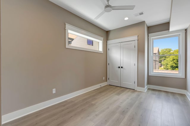 unfurnished bedroom featuring light hardwood / wood-style flooring, ceiling fan, and a closet