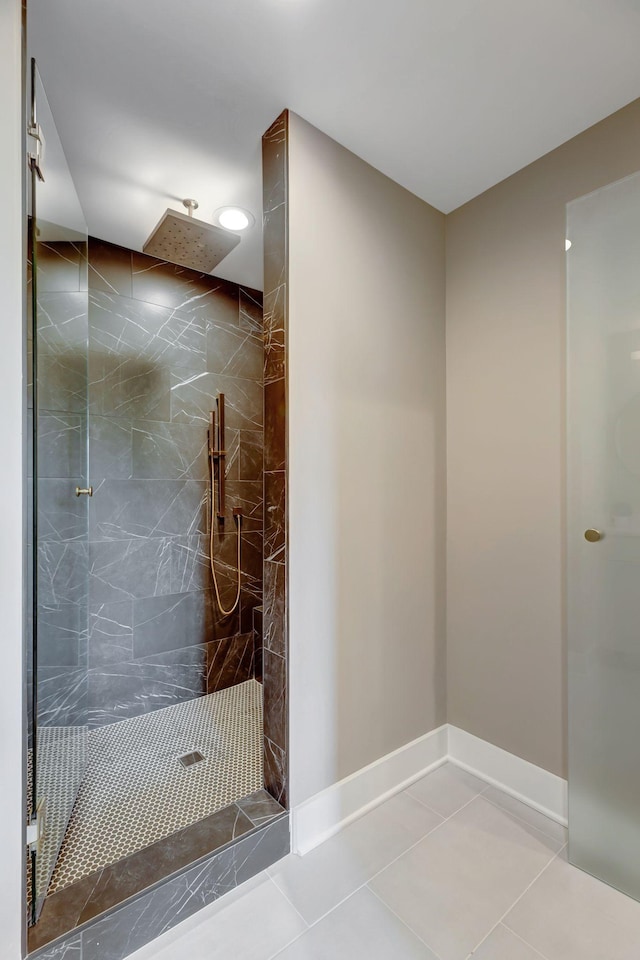 bathroom featuring tiled shower and tile patterned flooring