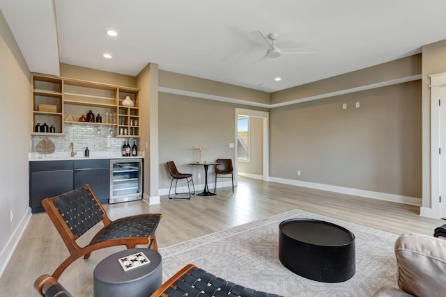 living area with wine cooler, light wood finished floors, recessed lighting, wet bar, and baseboards