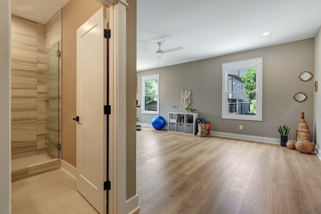 exercise area featuring baseboards, plenty of natural light, and light wood-style floors