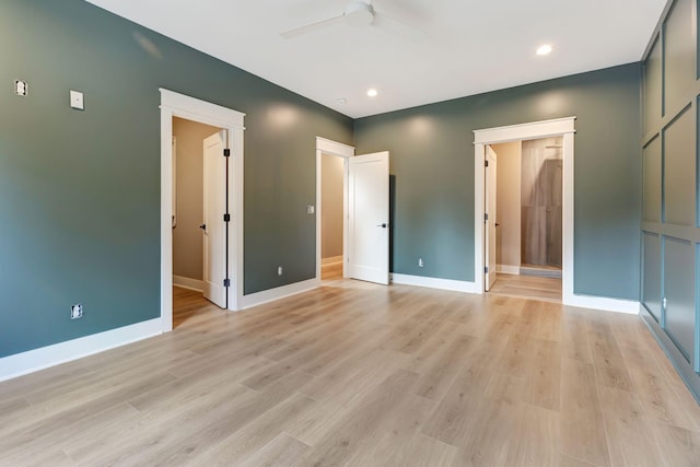 unfurnished bedroom featuring ensuite bathroom, light wood-type flooring, and ceiling fan