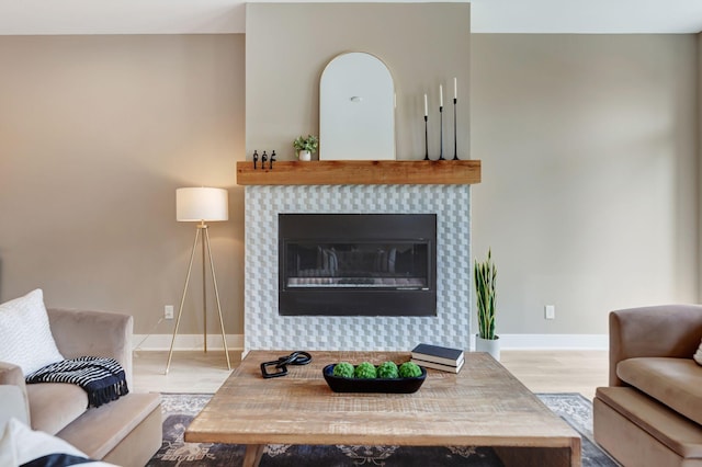 living room with light hardwood / wood-style flooring and a tile fireplace