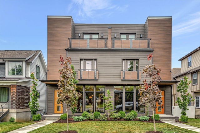 modern home with a balcony and a front yard