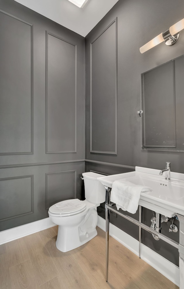 bathroom featuring wood-type flooring and toilet