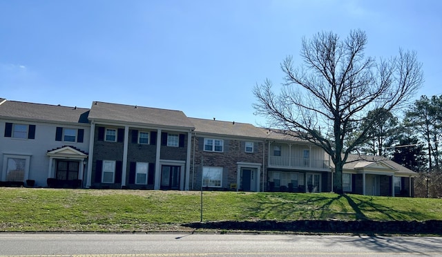 townhome / multi-family property with a front yard