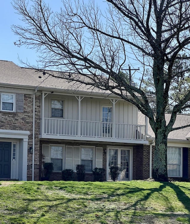 exterior space featuring a balcony and a front yard