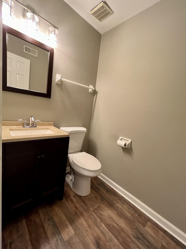 bathroom featuring vanity, hardwood / wood-style flooring, and toilet