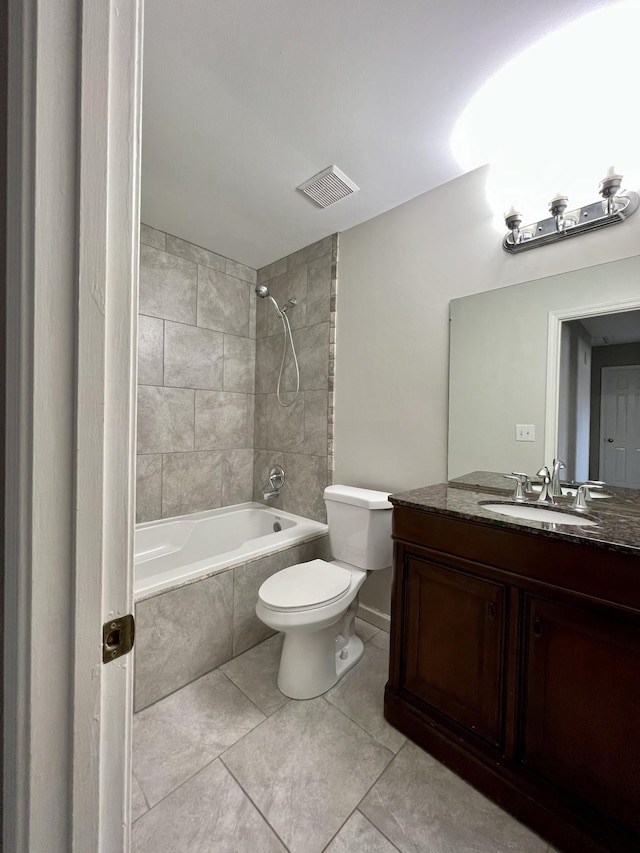 full bathroom featuring tile patterned floors, vanity, tiled shower / bath combo, and toilet