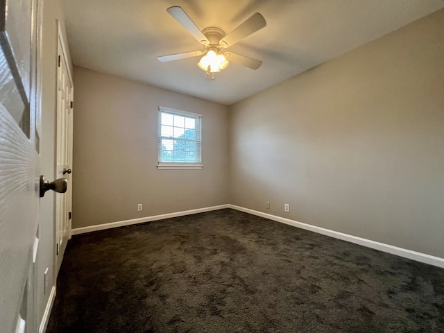 empty room with ceiling fan and dark carpet