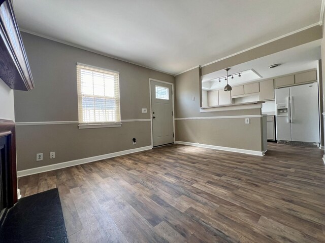 unfurnished living room featuring dark hardwood / wood-style floors and ornamental molding