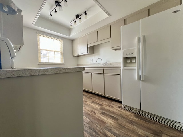 kitchen featuring dark hardwood / wood-style flooring, a tray ceiling, white fridge with ice dispenser, and sink