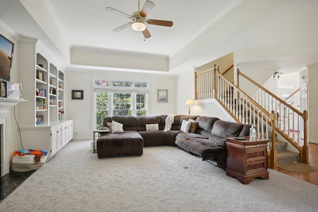 living room with ceiling fan, a high end fireplace, and ornamental molding