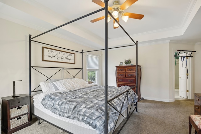 carpeted bedroom with ceiling fan, a tray ceiling, and crown molding