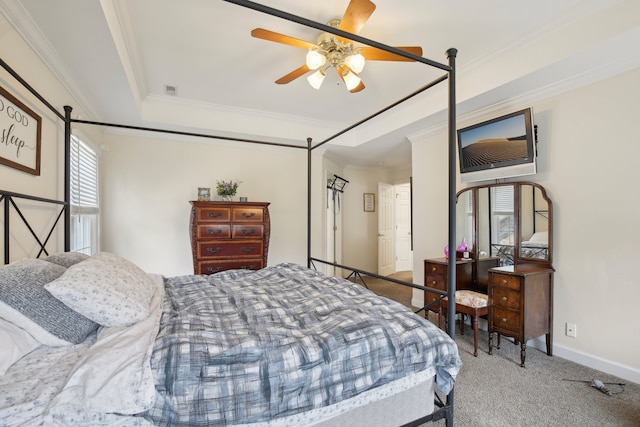 bedroom featuring ceiling fan, a tray ceiling, ornamental molding, and carpet flooring