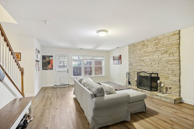 living room featuring light hardwood / wood-style flooring and a stone fireplace