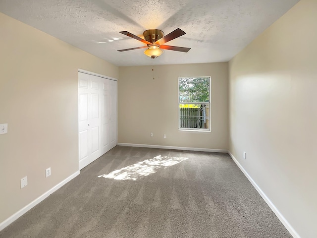 unfurnished bedroom with ceiling fan, carpet floors, a textured ceiling, and a closet