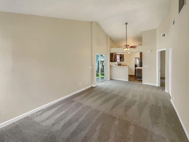 unfurnished living room with ceiling fan, carpet floors, and high vaulted ceiling