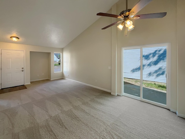 unfurnished living room featuring light carpet, ceiling fan, and high vaulted ceiling