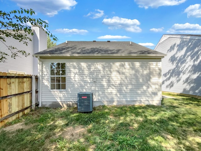 view of property exterior with central AC unit and a yard