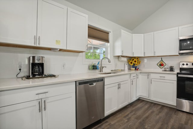 kitchen with lofted ceiling, sink, white cabinetry, dark hardwood / wood-style floors, and stainless steel appliances