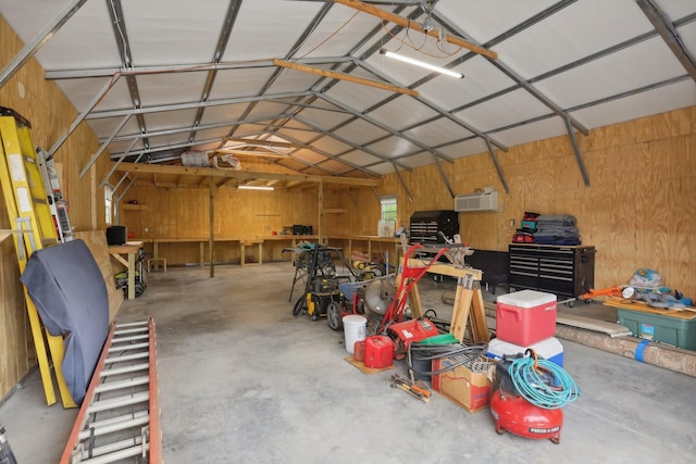 garage with wooden walls and a workshop area