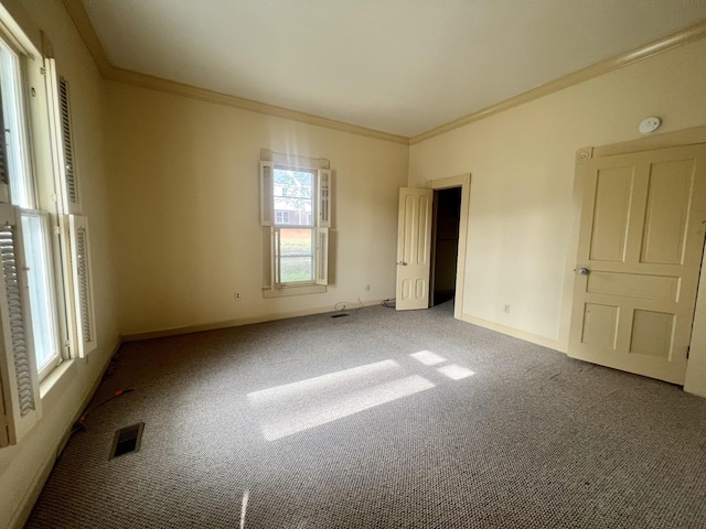 unfurnished room with carpet floors, a healthy amount of sunlight, and crown molding