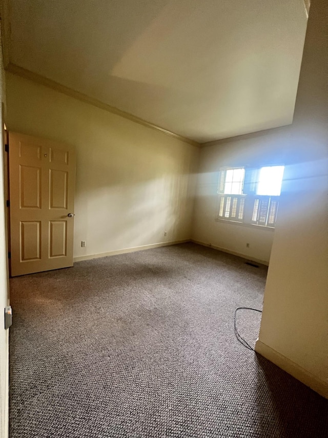 unfurnished room with ornamental molding and carpet flooring