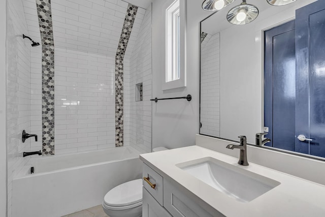 full bathroom featuring vanity, tiled shower / bath, and toilet