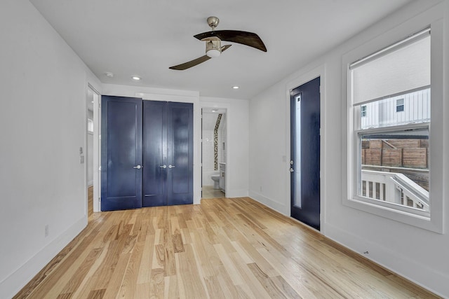 unfurnished bedroom featuring ensuite bath, ceiling fan, and light wood-type flooring