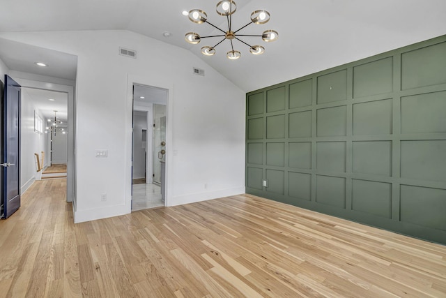 interior space featuring an inviting chandelier, lofted ceiling, and light wood-type flooring