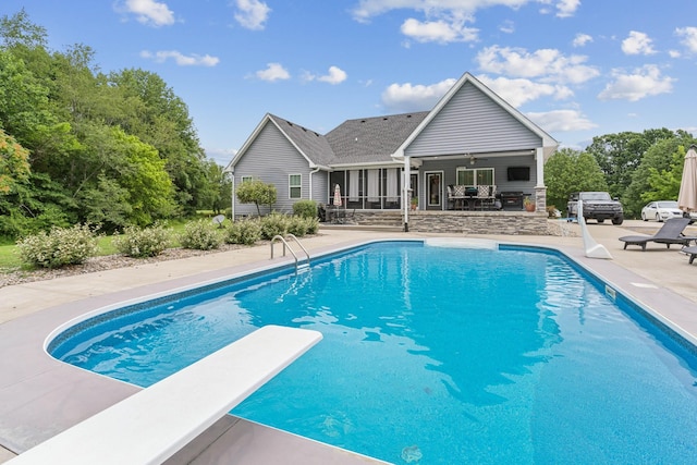 view of pool featuring a diving board, ceiling fan, and a patio area