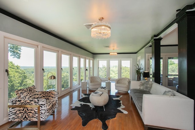 sunroom / solarium featuring french doors and a notable chandelier